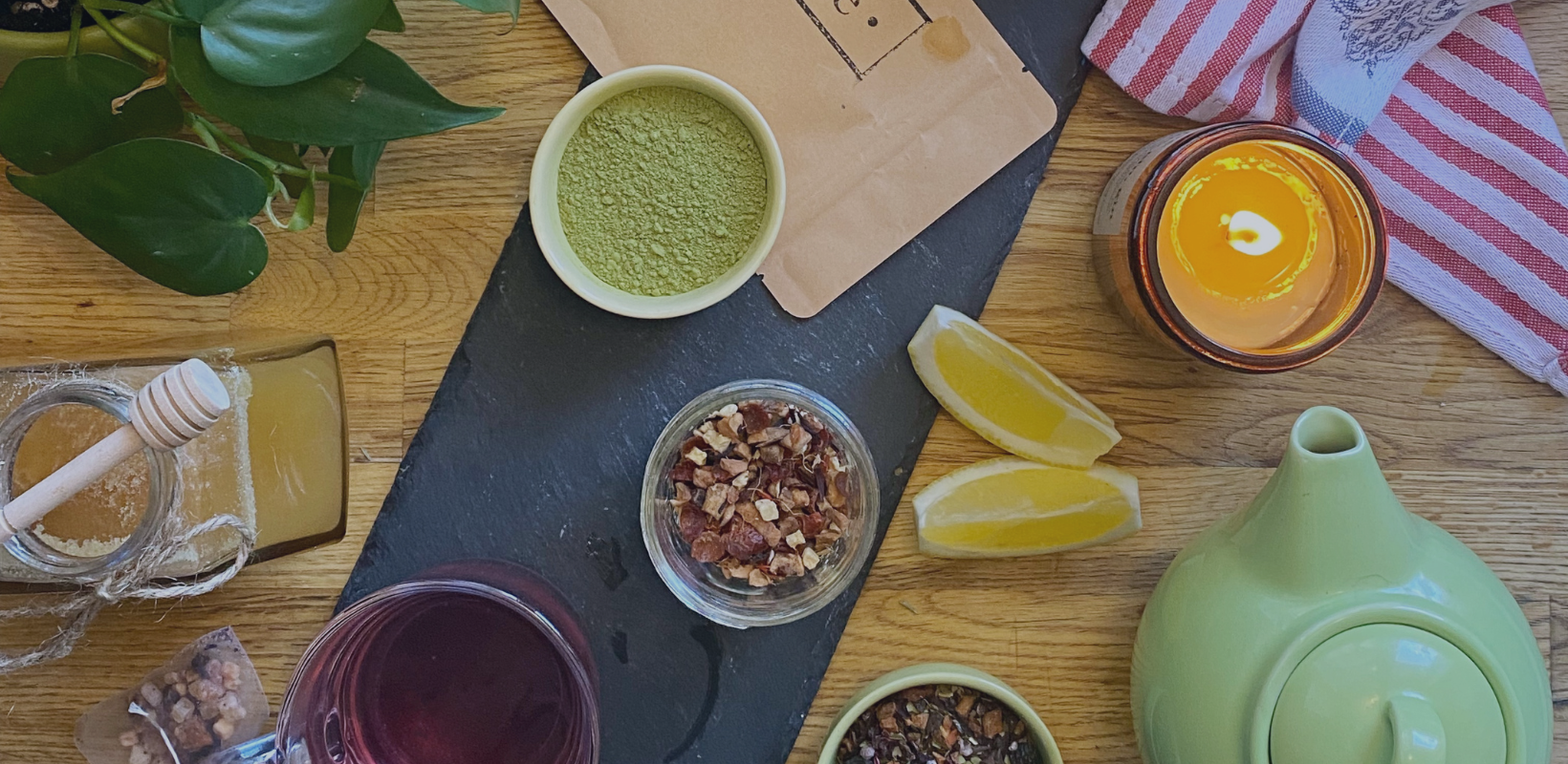 Loose leaf tea, lemons, clear tea cups and vintage tea pot appear from an overhead view on a wooden countertop. Explore unique flavours and comfort classics with T. Kettle natually sourced loose leaf tea. Join Teddy's Tea Club for more tea rewards.